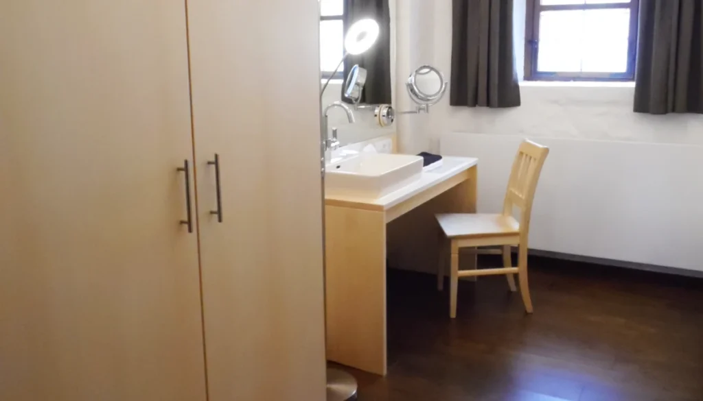 Künstlerzimmer Ballenhaus Schongau – Ahornschrank und Schminktisch mit Aufsatzwaschbecken auf Eicheparkett