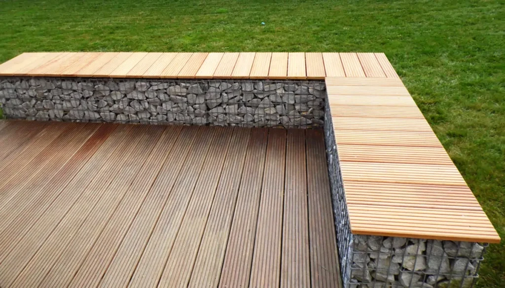 L-förmige Gabionen-Terrassenbank mit Garapa-Holzauflage als Abschluss einer Holzterrasse