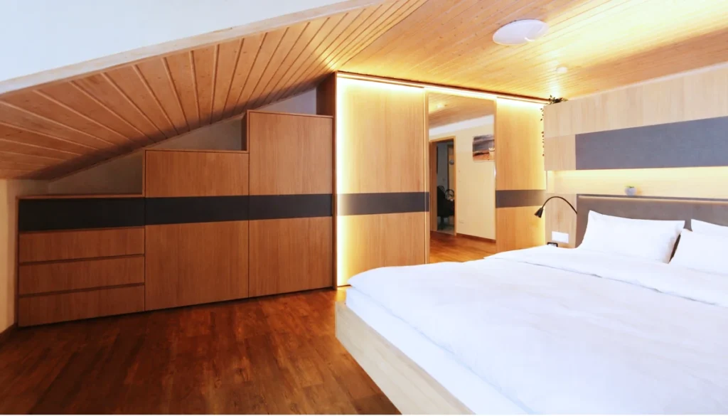 Maßgefertigtes Schlafzimmer aus Eiche in Altenstadt mit Schrankwand unter der Dachschräge, LED-Licht und schwebendem Bett.