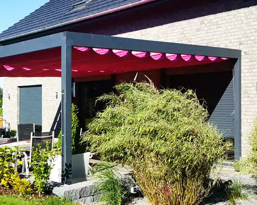 Moderner Outdoor Sonnenschutz mit Soliday raffbarem Sonnensegel über einer Terrasse an einem Einfamilienhaus.