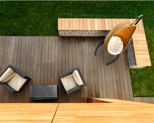 Holzterrasse mit Loungemöbeln, Gabionenbank und Hängesessel in modernem Gartenambiente