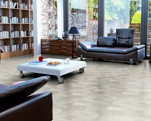 Wohnzimmer mit Vinylboden in Steinoptik, brauner Ledercouch, weißem Rolltisch mit Tassen und Gebäck, Bücherregal und Stehlampe vor großen Fenstern