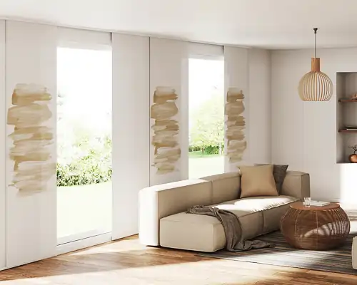 Helles Wohnzimmer mit großen Fenstern, die mit MHZ Flächenvorhängen ausgestattet sind. Die Vorhänge sind weiß mit vertikalen, unregelmäßigen, beige-braunen Pinselstrichmustern. Vor den Fenstern steht eine moderne, beige Eckcouch mit einem braunen Kissen und einer dunkelgrauen Decke. Ein runder, geflochtener Couchtisch aus Holz steht davor. An der Decke hängt eine hölzerne Pendelleuchte mit schmalen Lamellen. Rechts im Raum ist ein offenes Regal mit Dekorationsgegenständen zu sehen. Der Boden ist aus hellem Holz.