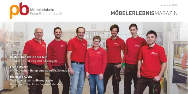 Möbelerlebnis Team von sieben Personen in roten Poloshirts, stehenin der Schreinerei