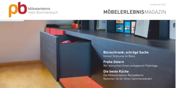 Offener schwarzer Büroschrank mit Schwarzen omd roten Schubladen auf hellem Holzboden, im Hintergrund Bilder und Dekoration.