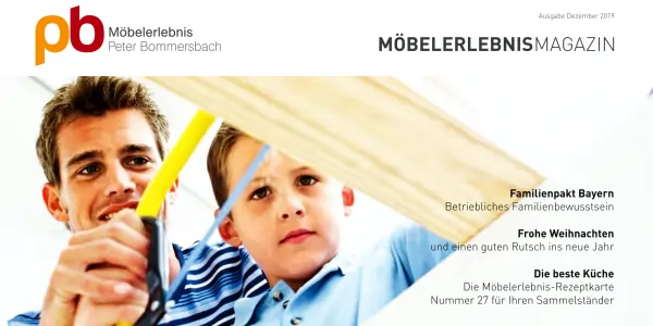Vater und Sohn im blauen Hemden halten ein großes Holzbrett vor sich, im Hintergrund das Logo von Möbelerlebnis Peter Bommersbach und der Schriftzug 'MÖBELERLEBNISMAGAZIN' mit Weihnachts- und Familienpakt-Bayern-Grüßen.