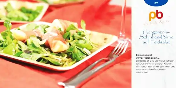 Rezeptkarte für Gorgonzola-Schinken-Birne auf Feldsalat mit Text und Bild eines angerichteten Salats auf weißem Teller, daneben Besteck und roter Hintergrund.