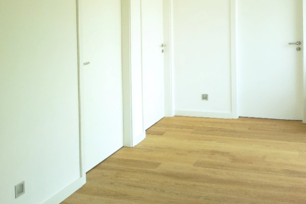 Heller Parkettboden mit weißen Zimmertüren in einem modern gestalteten Flur