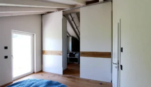 Begehbarer Kleiderschrank unter Dachschräge in Rottenbuch mit raumhohen Schiebetüren