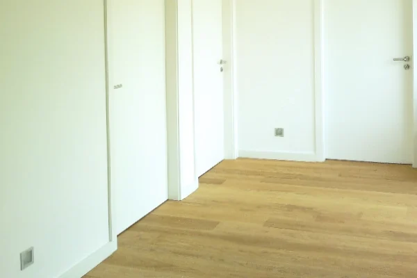 Heller Parkettboden mit weißen Zimmertüren in einem modern gestalteten Flur
